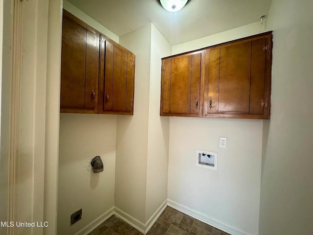 washroom featuring hookup for a washing machine, cabinet space, and baseboards