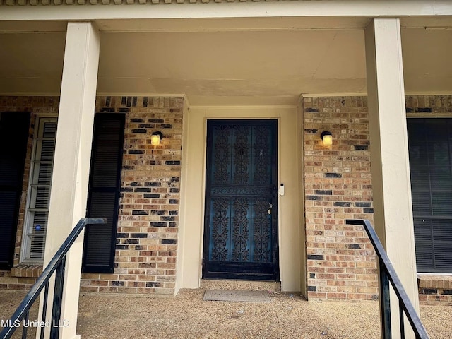 entrance to property featuring brick siding