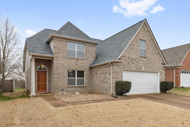 traditional home featuring driveway, brick siding, and roof with shingles