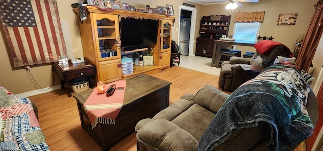 living room featuring ceiling fan, wood finished floors, and baseboards