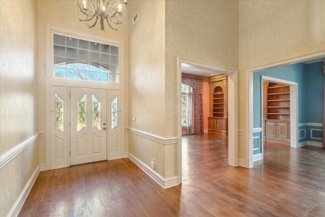 962 E Riverwalk Dr E, Memphis, TN 38120 - foyer entrance featuring a wainscoted wall, a notable chandelier, visible vents, a high ceiling, and wood finished floors