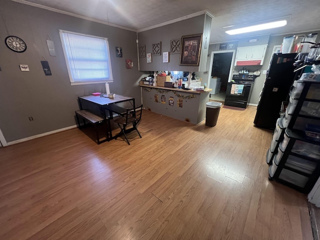 interior space featuring light wood finished floors, baseboards, ornamental molding, a peninsula, and black electric range