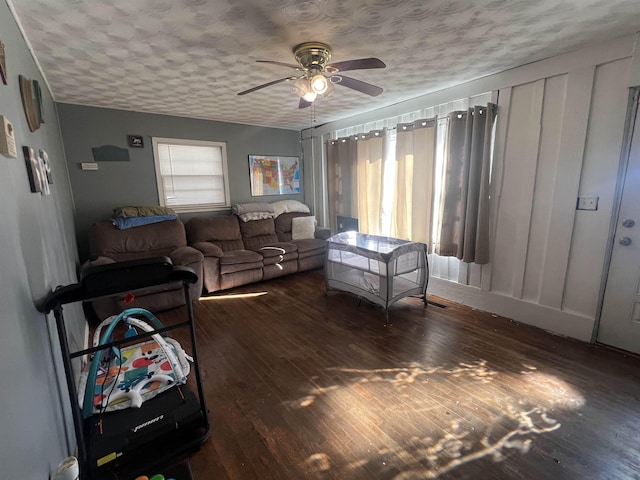 living area featuring a healthy amount of sunlight, dark wood finished floors, and a textured ceiling