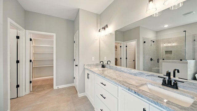 1405 Armstrong Rd, Drummonds, TN 38023 - bathroom featuring a stall shower, double vanity, a walk in closet, tile patterned flooring, and baseboards
