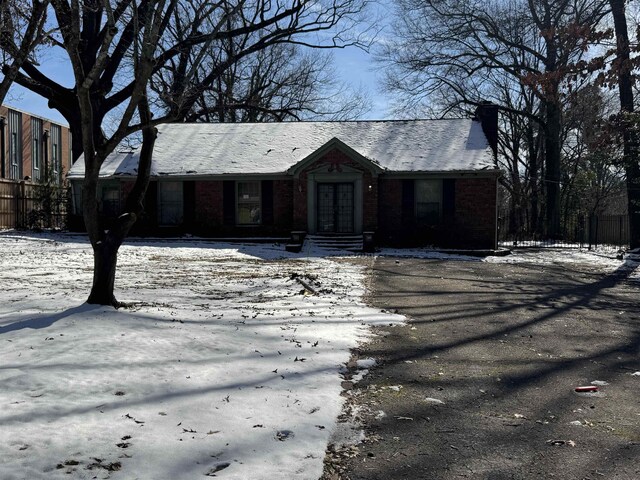 view of front facade featuring brick siding and a chimney