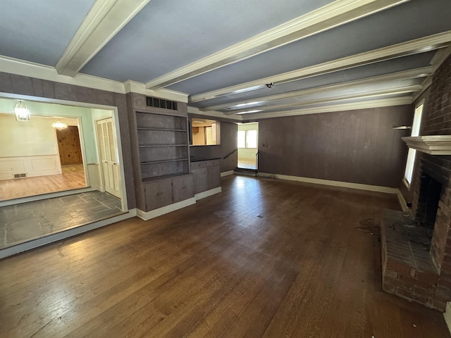 unfurnished living room with a brick fireplace, visible vents, dark wood finished floors, and beam ceiling