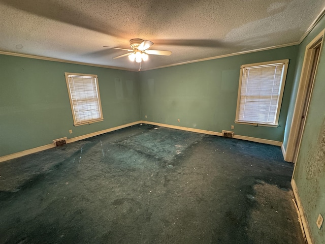 unfurnished room with a textured ceiling, a ceiling fan, baseboards, visible vents, and crown molding