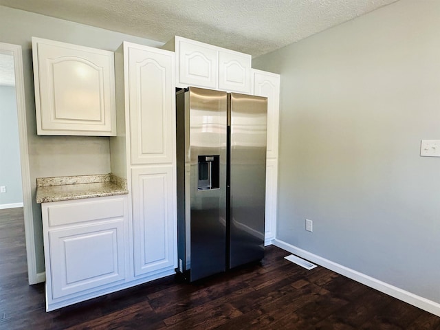 kitchen with baseboards, stainless steel fridge with ice dispenser, dark wood-style floors, a textured ceiling, and white cabinetry