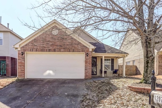 view of front of property with an attached garage, fence, concrete driveway, and brick siding