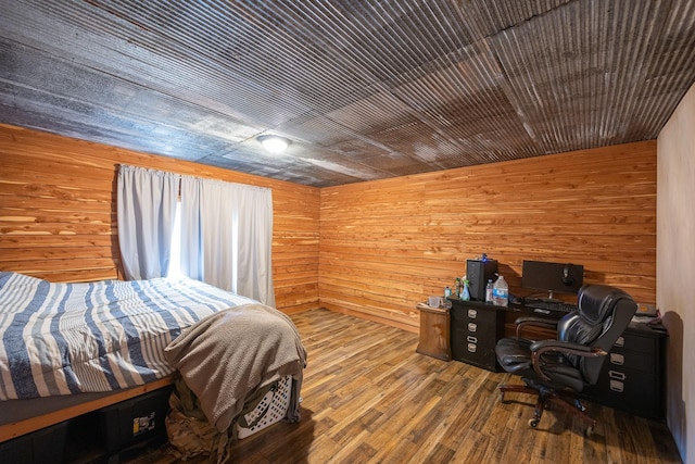 bedroom with wood ceiling, wooden walls, and wood finished floors