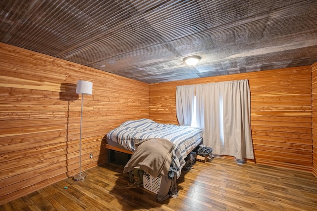 bedroom featuring wooden walls and wood finished floors
