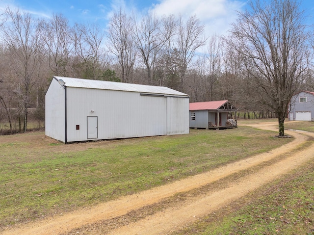 view of home's exterior featuring metal roof, a lawn, and driveway