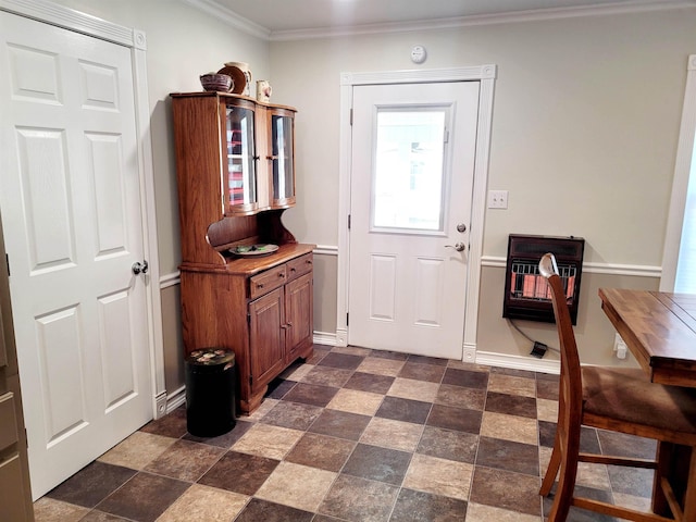 doorway with ornamental molding, stone finish floor, baseboards, and heating unit