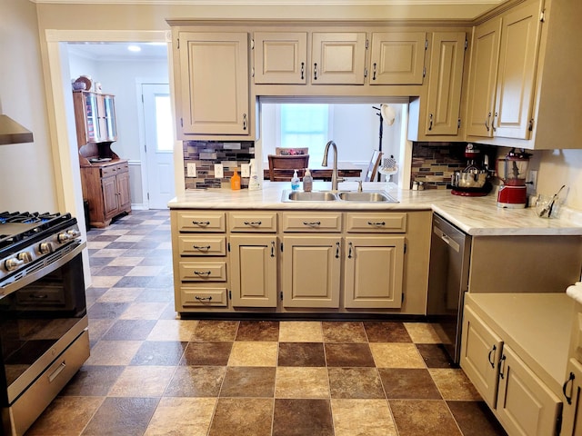 kitchen featuring a sink, light countertops, appliances with stainless steel finishes, cream cabinetry, and decorative backsplash