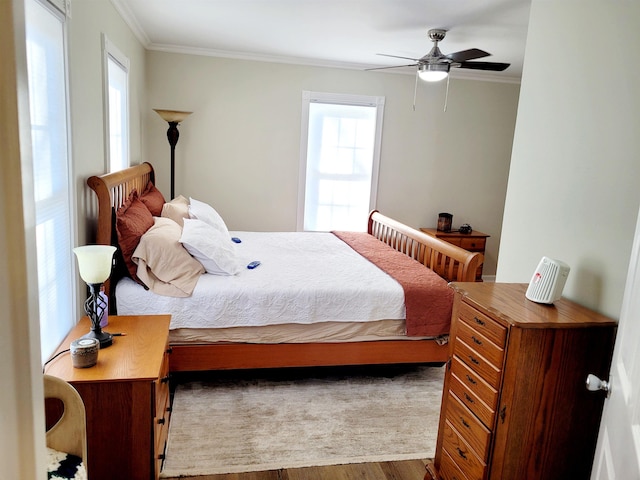 bedroom featuring light wood-style floors, a ceiling fan, and crown molding