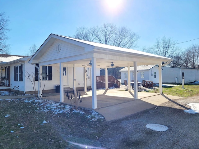 view of vehicle parking featuring ceiling fan, a carport, and driveway