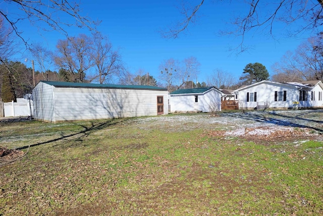 back of property with fence and a lawn