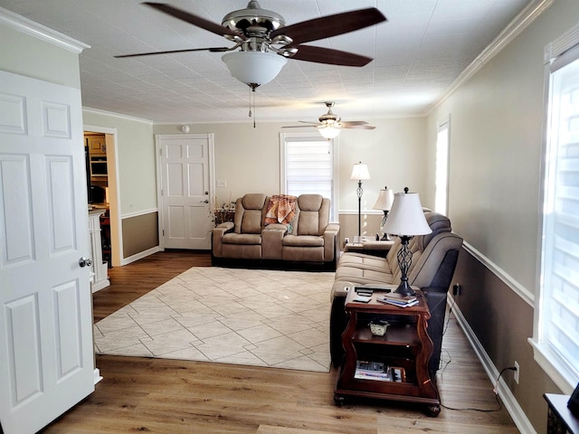 living room featuring ornamental molding, a healthy amount of sunlight, and wood finished floors