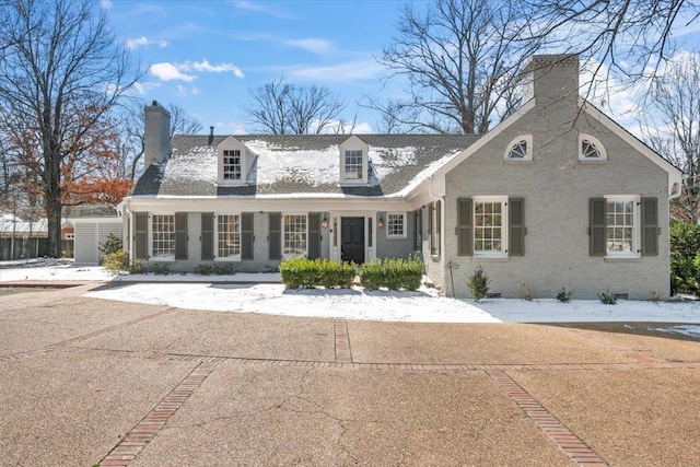 view of front facade featuring crawl space, covered porch, a chimney, and brick siding