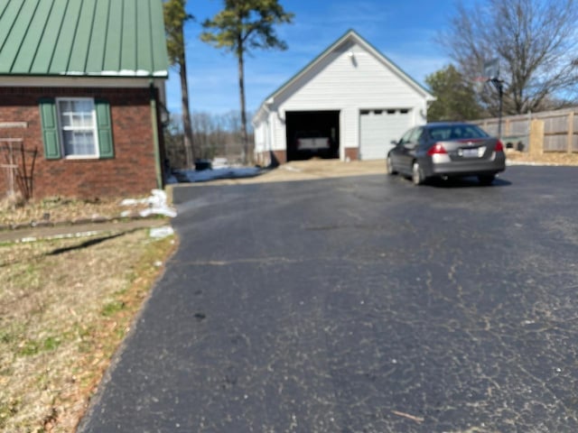 exterior space featuring metal roof, brick siding, a standing seam roof, and a detached garage