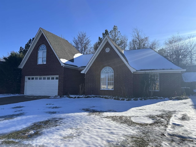 view of front facade featuring driveway, brick siding, and an attached garage