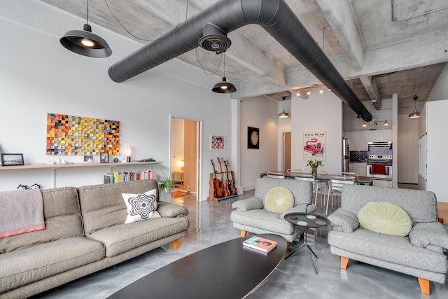 living room featuring finished concrete flooring and a high ceiling