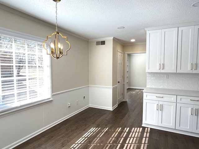 unfurnished dining area featuring dark wood-style flooring, visible vents, plenty of natural light, and a textured ceiling