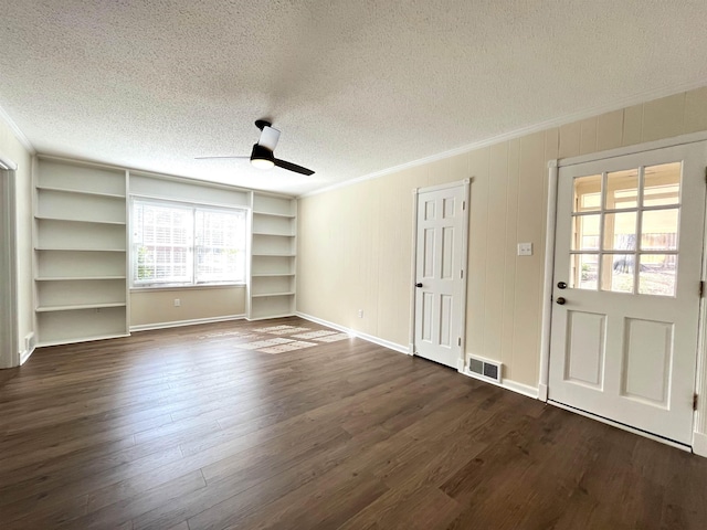 unfurnished living room with dark wood-style floors, a textured ceiling, visible vents, and crown molding