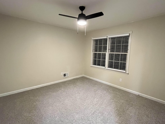 spare room with ceiling fan, carpet flooring, visible vents, and baseboards