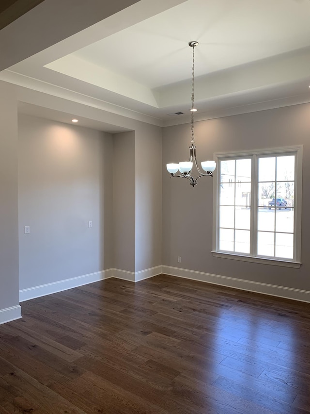 unfurnished room featuring a tray ceiling, dark wood-style flooring, and baseboards