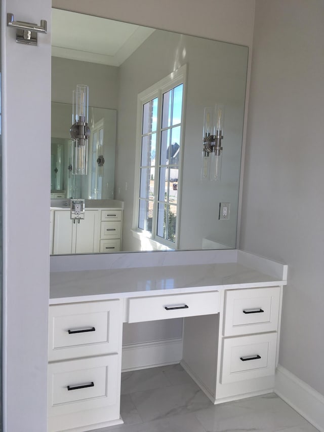 bathroom featuring marble finish floor, vanity, and baseboards