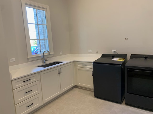 laundry room featuring cabinet space, a sink, and washing machine and clothes dryer