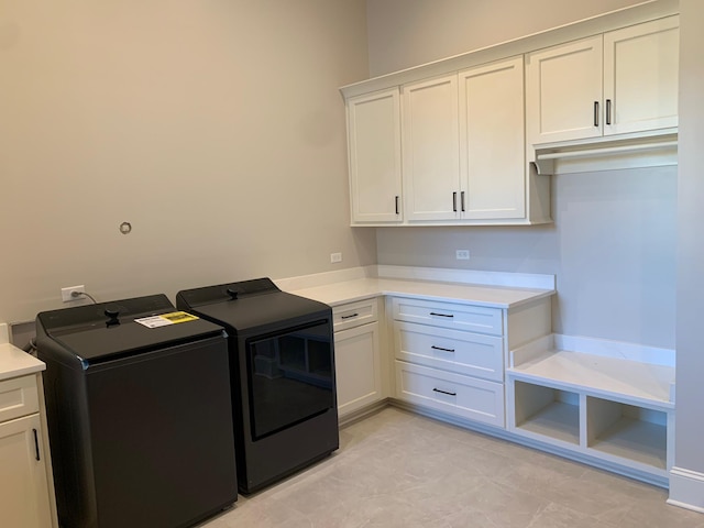 clothes washing area with cabinet space and independent washer and dryer