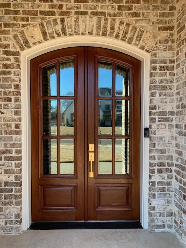 doorway to property featuring brick siding