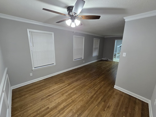 unfurnished room with baseboards, ceiling fan, ornamental molding, dark wood-style flooring, and a textured ceiling