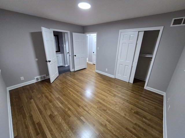 unfurnished bedroom featuring dark wood finished floors, visible vents, and baseboards