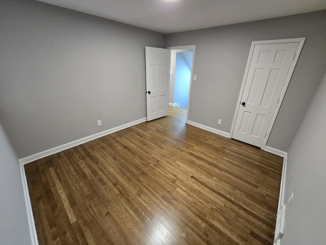 unfurnished bedroom with baseboards and wood finished floors