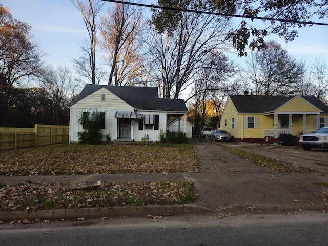 bungalow-style house featuring driveway and fence