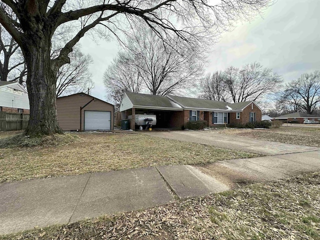 view of front facade with a garage, an outbuilding, brick siding, and driveway