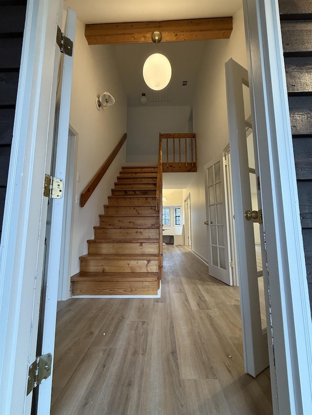 interior space with high vaulted ceiling, beamed ceiling, and wood finished floors