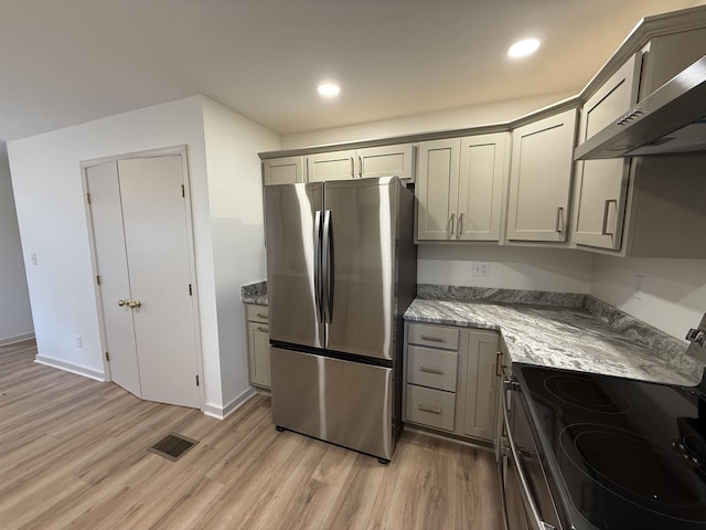 kitchen with wall chimney range hood, gray cabinets, visible vents, and stainless steel appliances