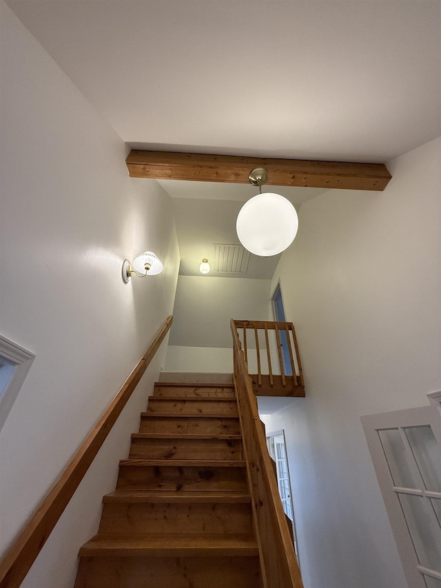 stairs featuring visible vents and beamed ceiling