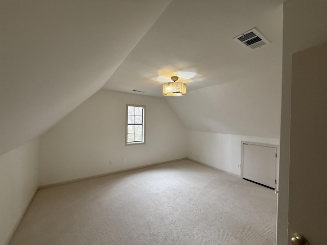 bonus room with lofted ceiling, light carpet, and visible vents