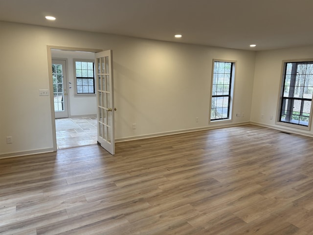 empty room with light wood-style flooring, plenty of natural light, visible vents, and recessed lighting