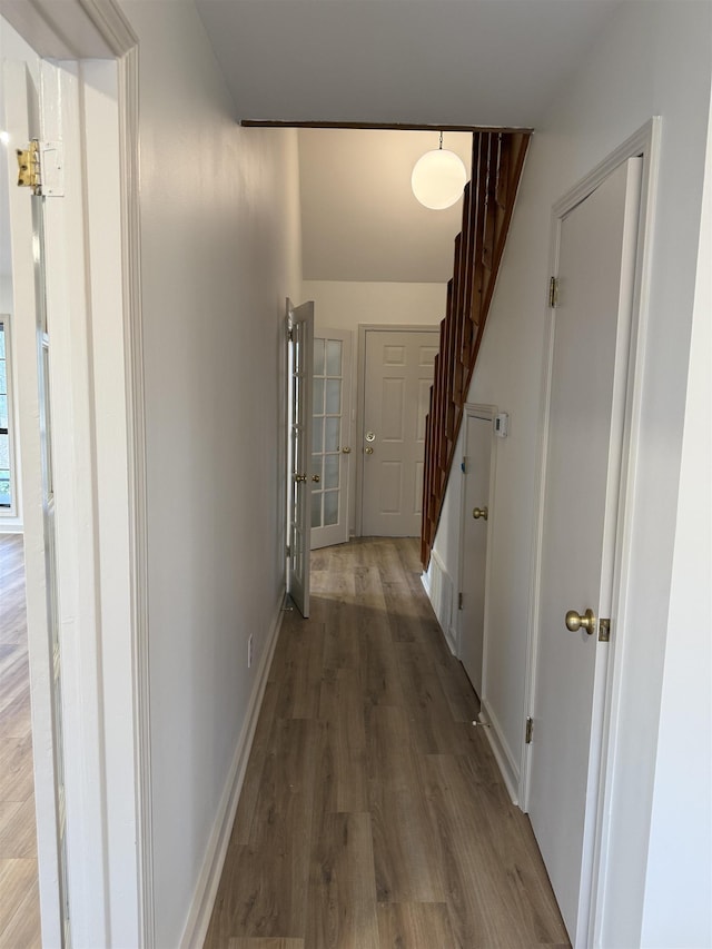 corridor with stairway, baseboards, and wood finished floors