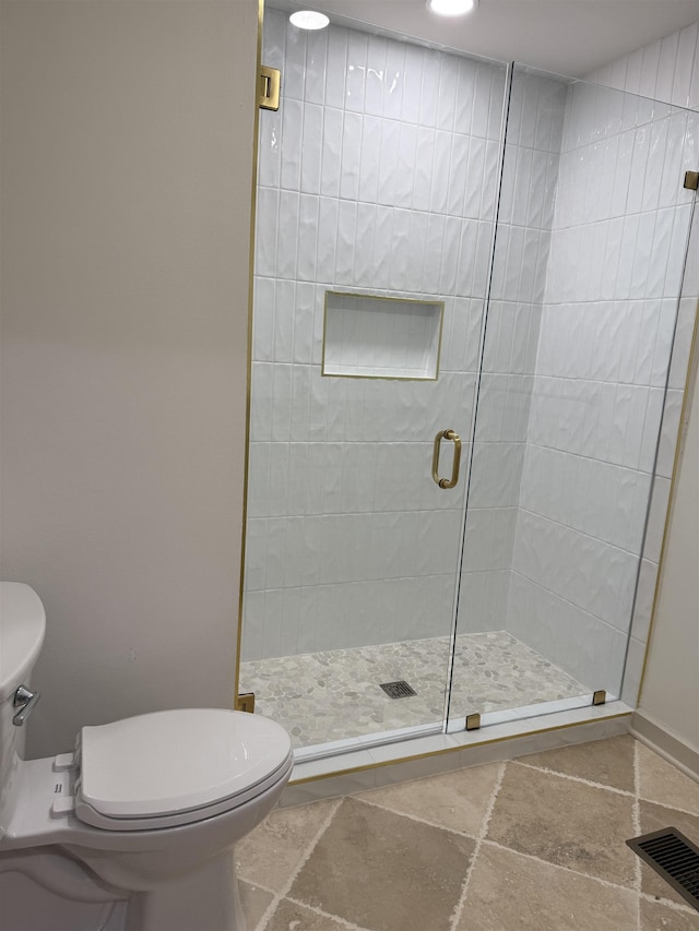 full bath with a stall shower, visible vents, toilet, and stone tile floors