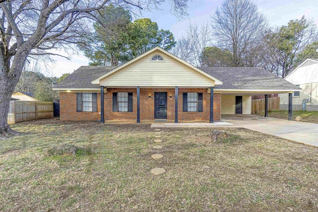 view of front facade with an attached carport, brick siding, fence, concrete driveway, and a front lawn