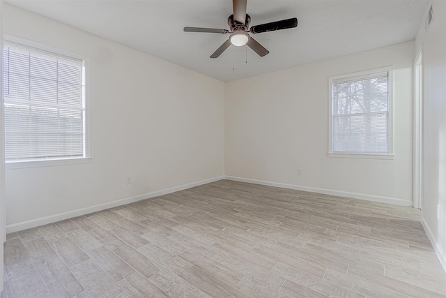 unfurnished room featuring light wood-style flooring, visible vents, ceiling fan, and baseboards