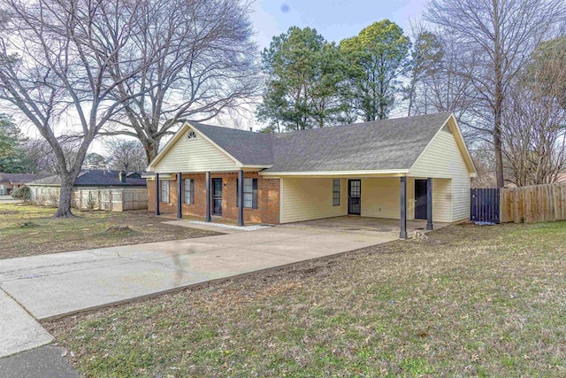 ranch-style home with an attached carport, concrete driveway, brick siding, and fence