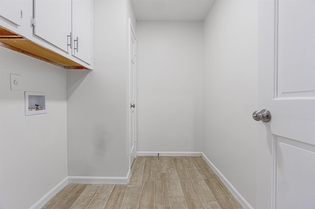 washroom with light wood-style floors, cabinet space, hookup for a washing machine, and baseboards